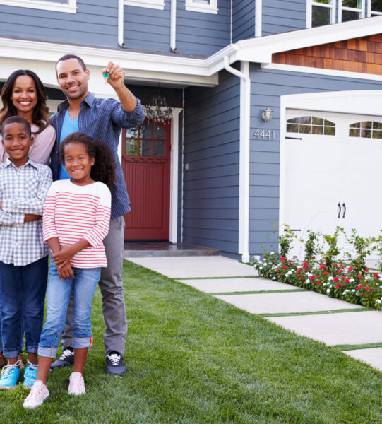 Happy black family standing outside their house, dad Happy black family standing outside their house, dad holding the key